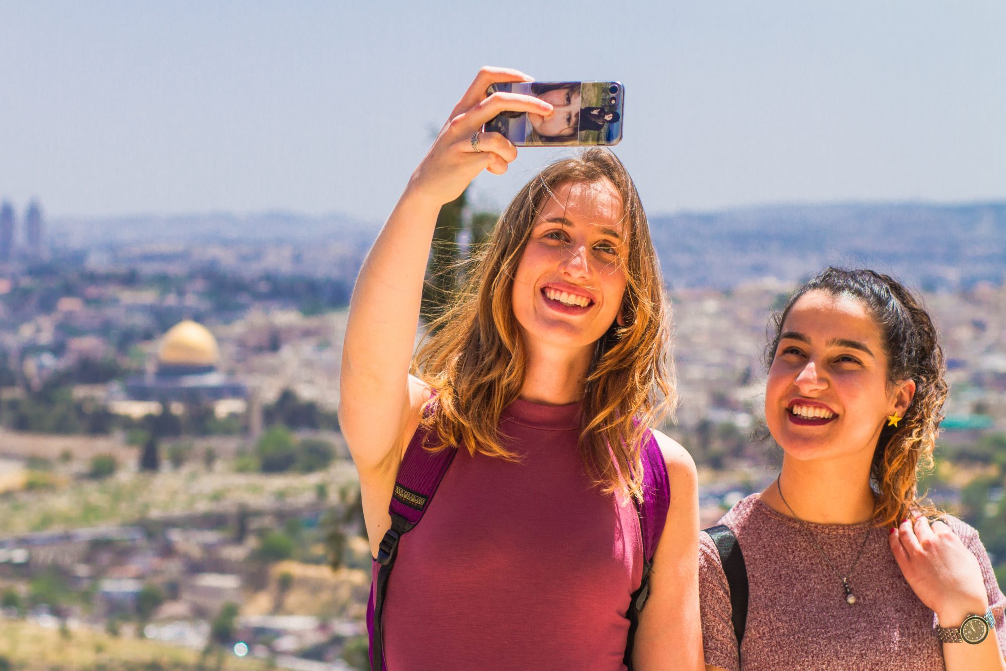 Two female students take photo with Jerusalem background