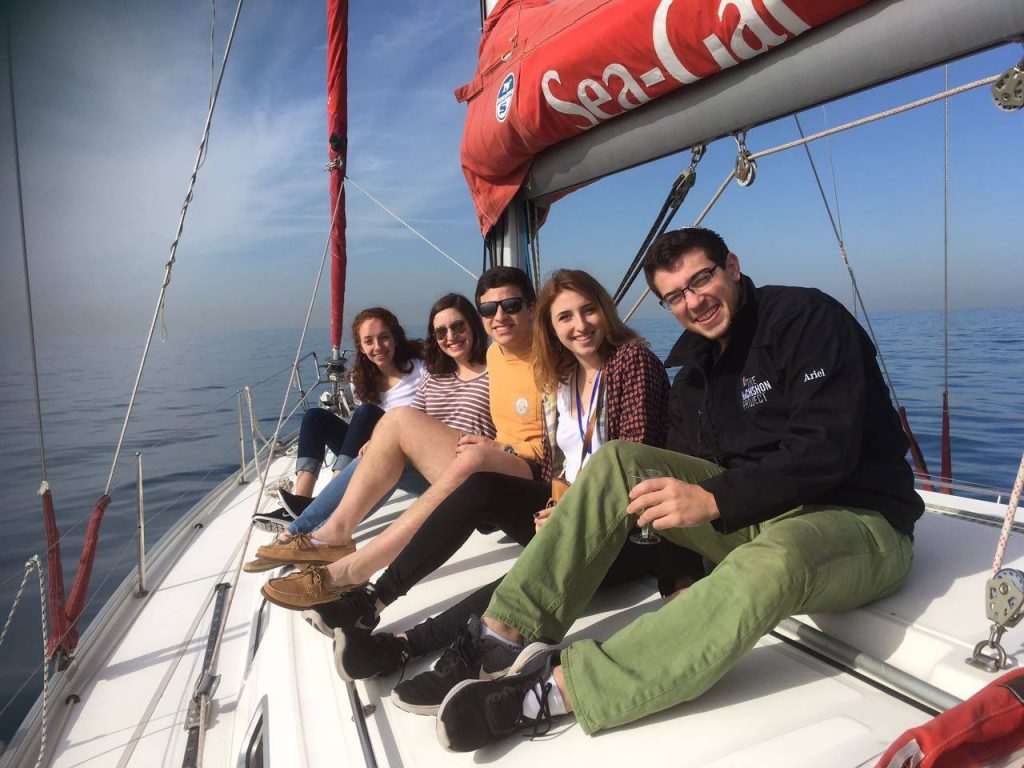 Group of students sitting on sailboat in water